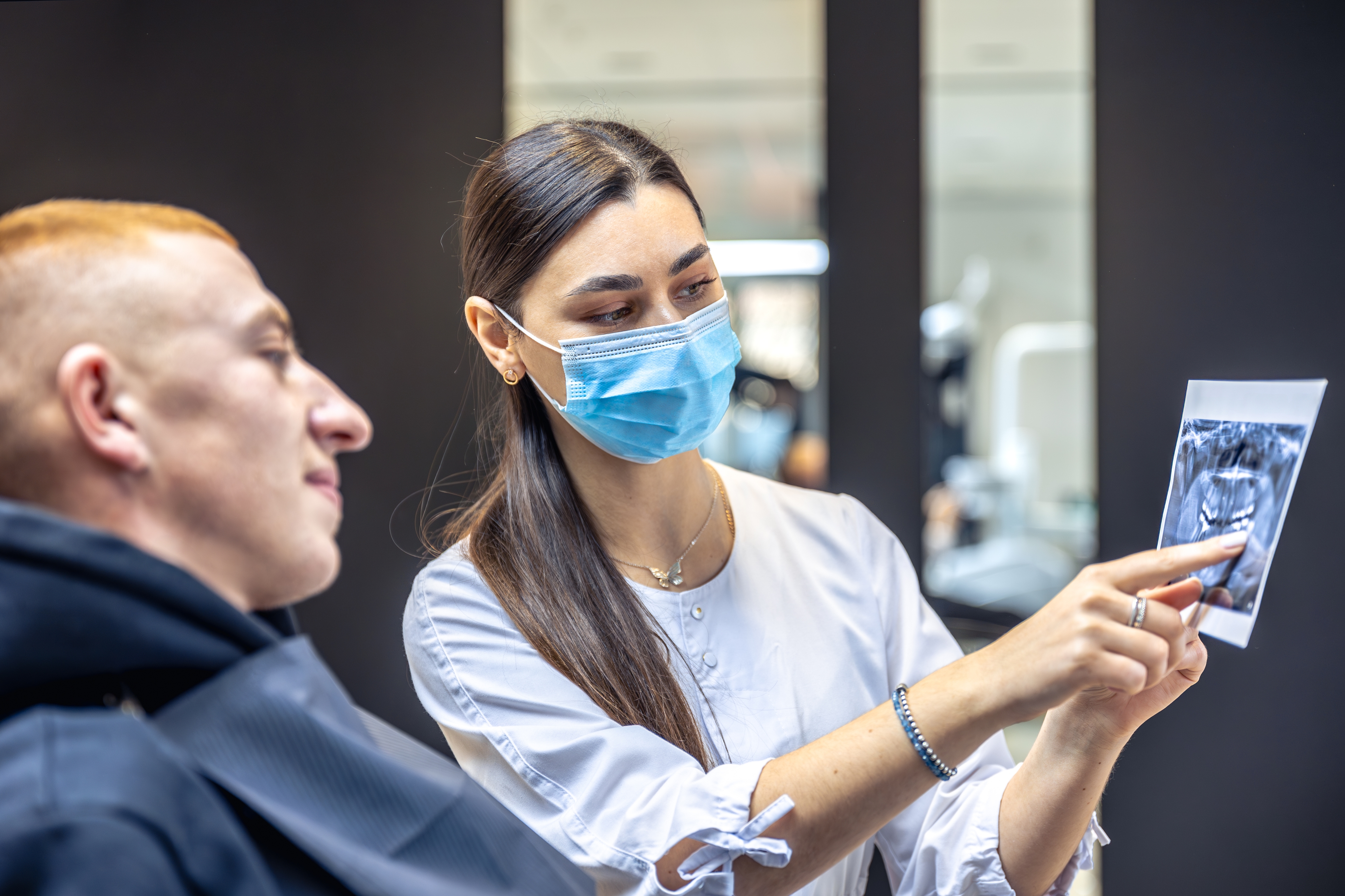 «Implantologist reviewing a CBCT scan with a patient at a JCI-accredited partner hospital — Firma Clinic Istanbul, dental implant safety 2026»